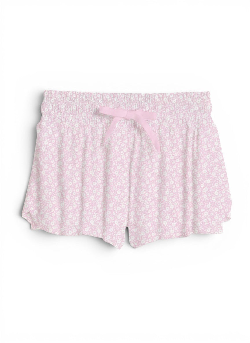 Vann & Liv blush pink floral print shorts with smocked waistband and pink bow detail.